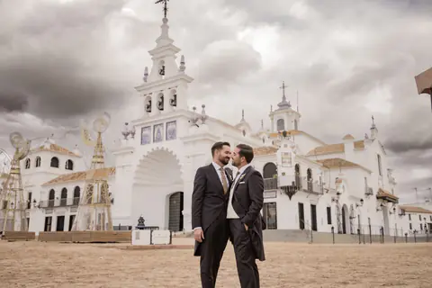 Los novios ante la fachada de la ermita de El Rocío, en Almonte (Huelva), bajo un cielo de tormenta