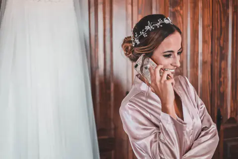 La novia habla por teléfono durante los preparativos, ya peinada y con el tocado puesto